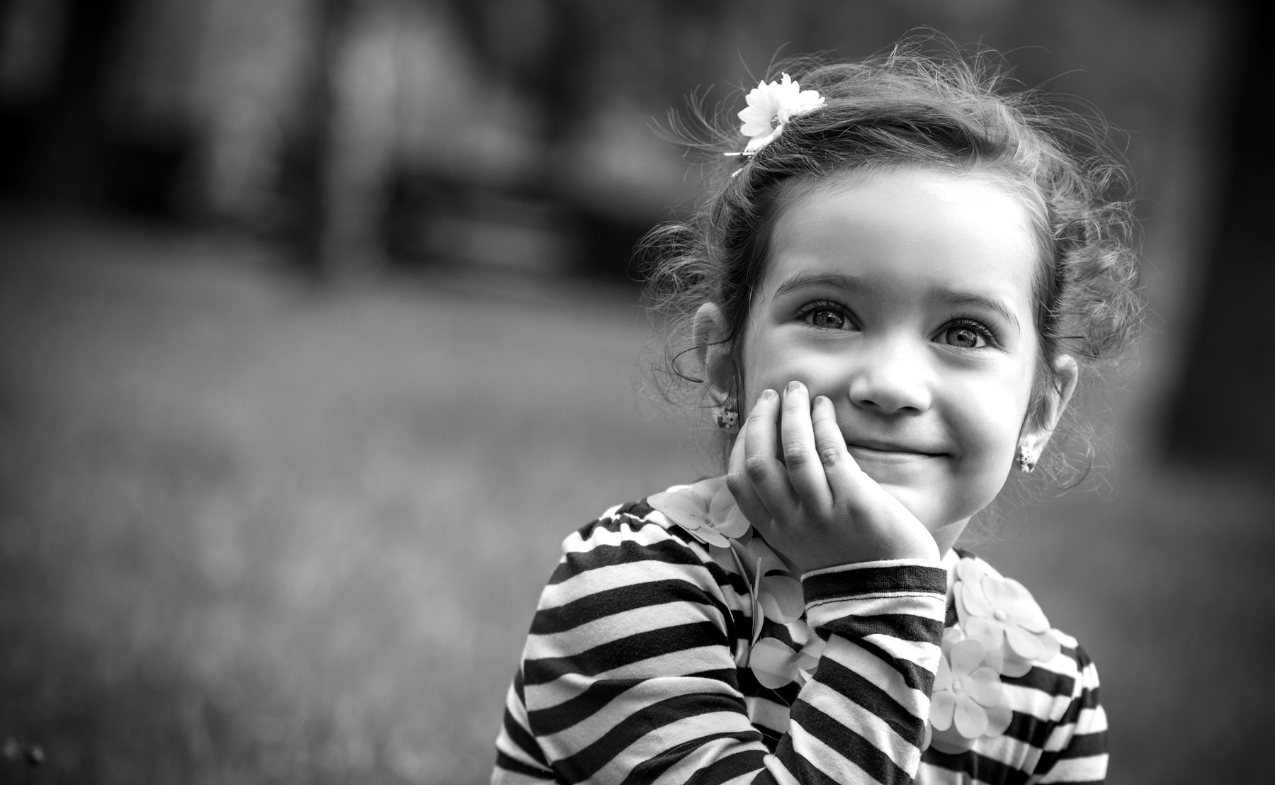 Black and white portrait of a young girl resting her chin on her hand